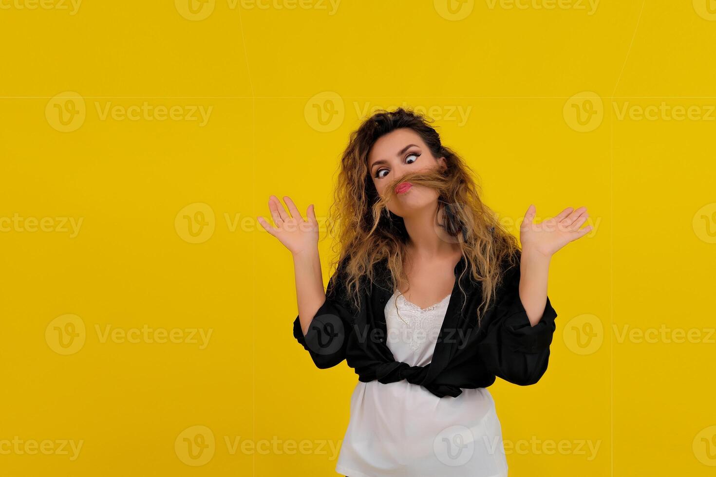 Close-up portrait of a beautiful girl on a yellow background. woman shows surprise. Shocked surprised stunned. positive human emotions photo