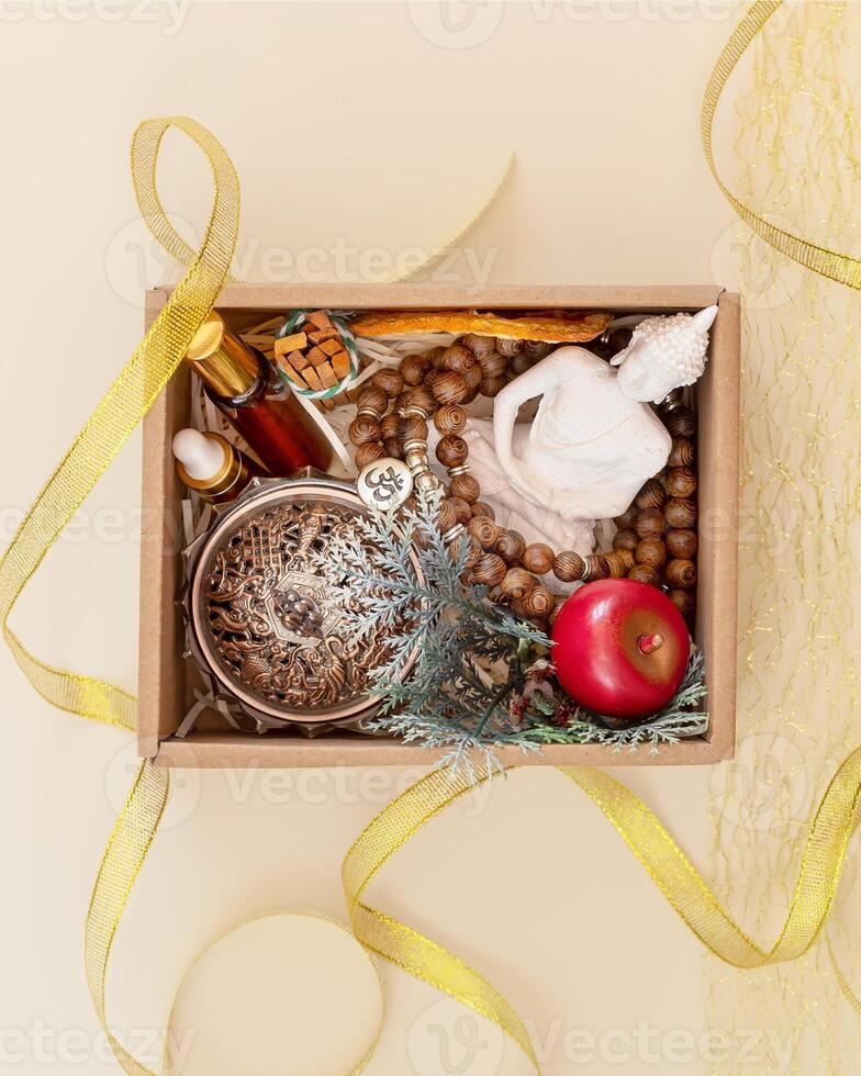 Gift box with buddha statue, aroma sticks and natural oils with gold ribbon photo