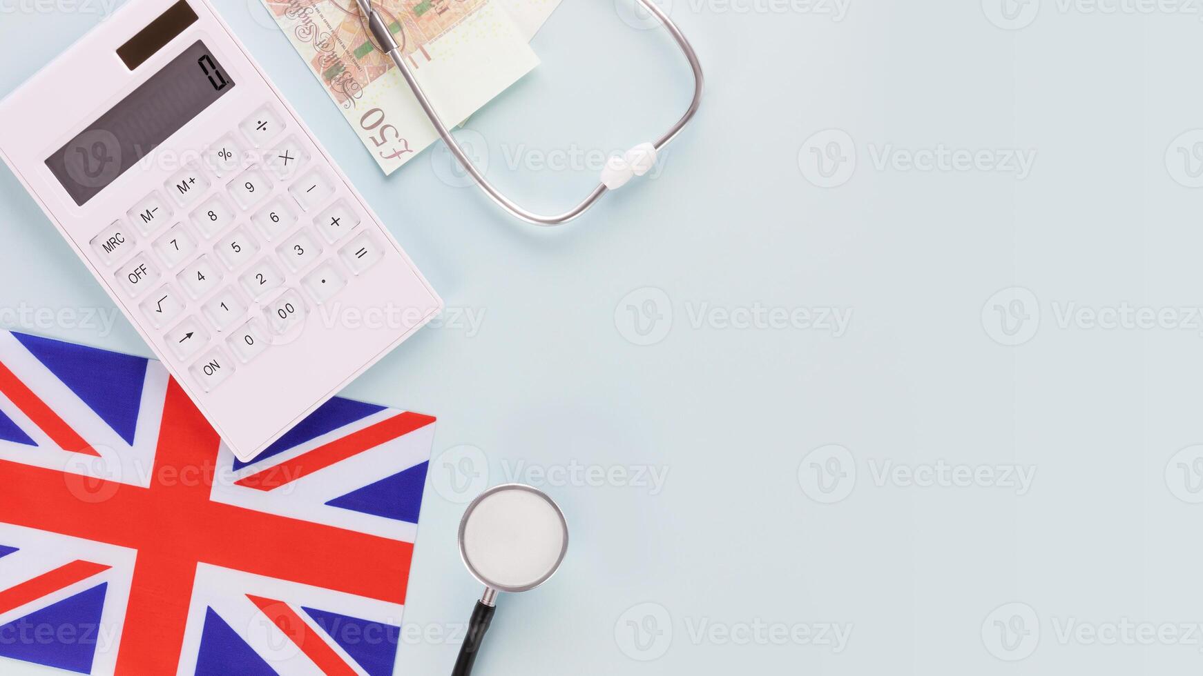 Calculator, stethoscope, flag of Great Britain and pounds with copy space photo