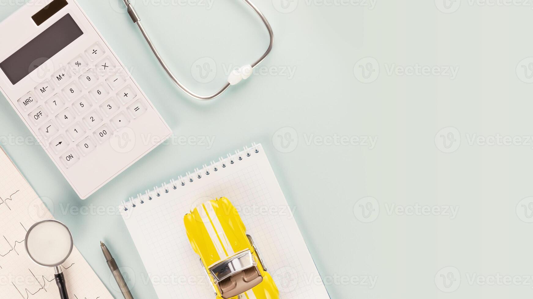 Calculator, stethoscope, cardiogram and toy car on a notepad photo