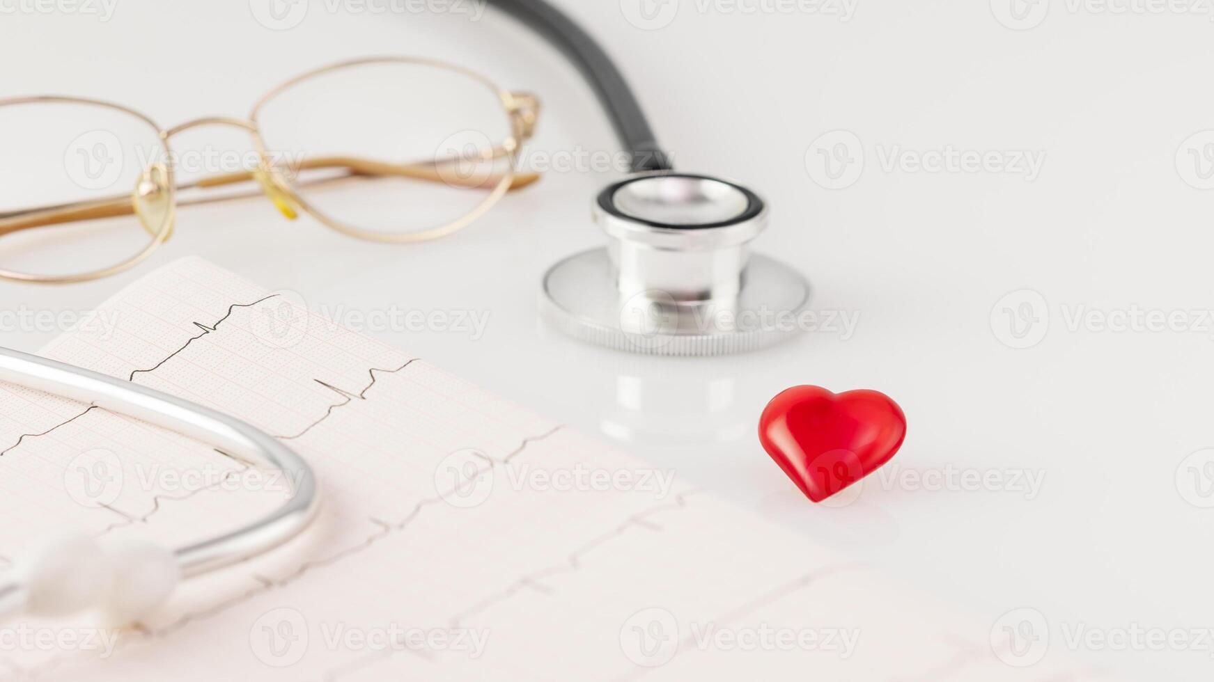 Stethoscope on cardiogram with glasses on a white doctor desk photo