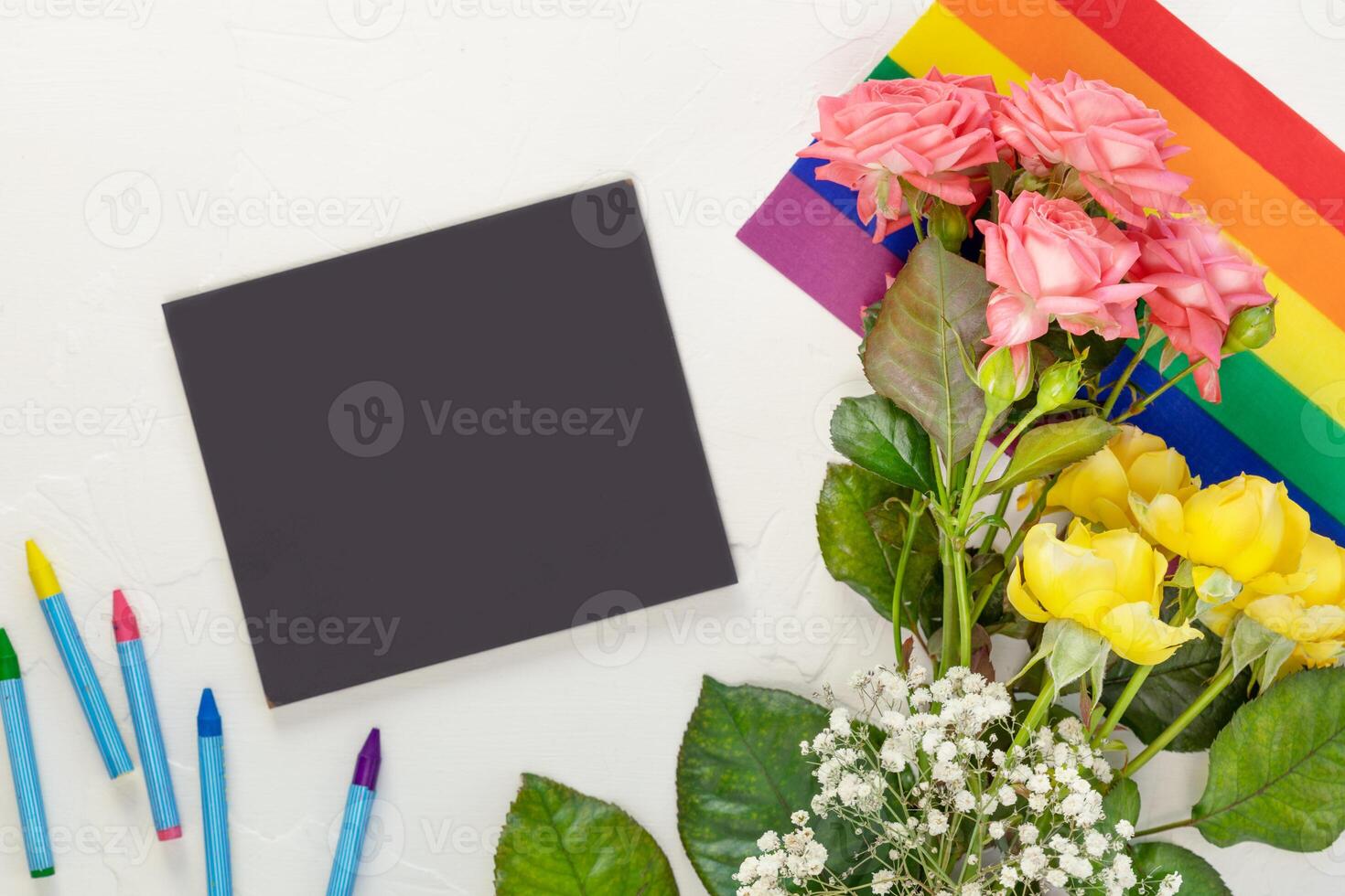 Roses on a rainbow flag and chalkboard with chalks photo
