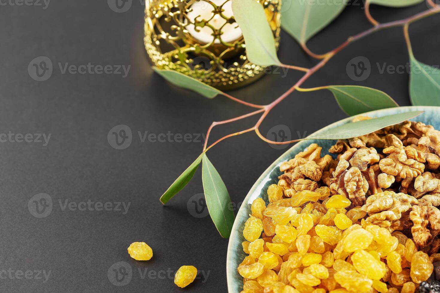 Nuts, dried fruits and dates in the blue bowl and ramadan lantern photo
