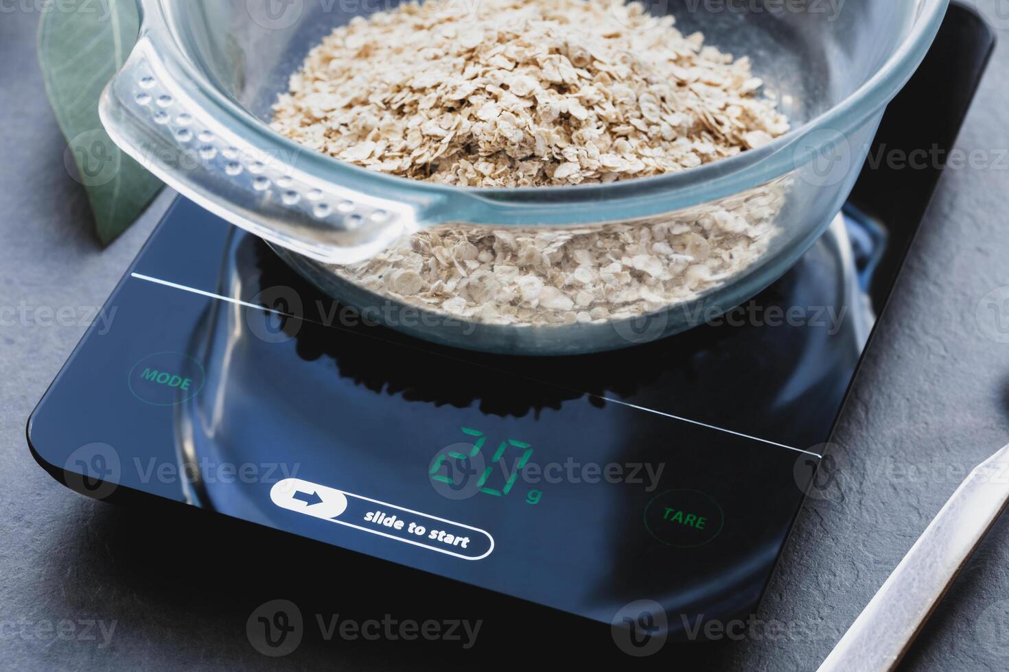 Natural oatmeal in a glass bowl on a kitchen scale photo
