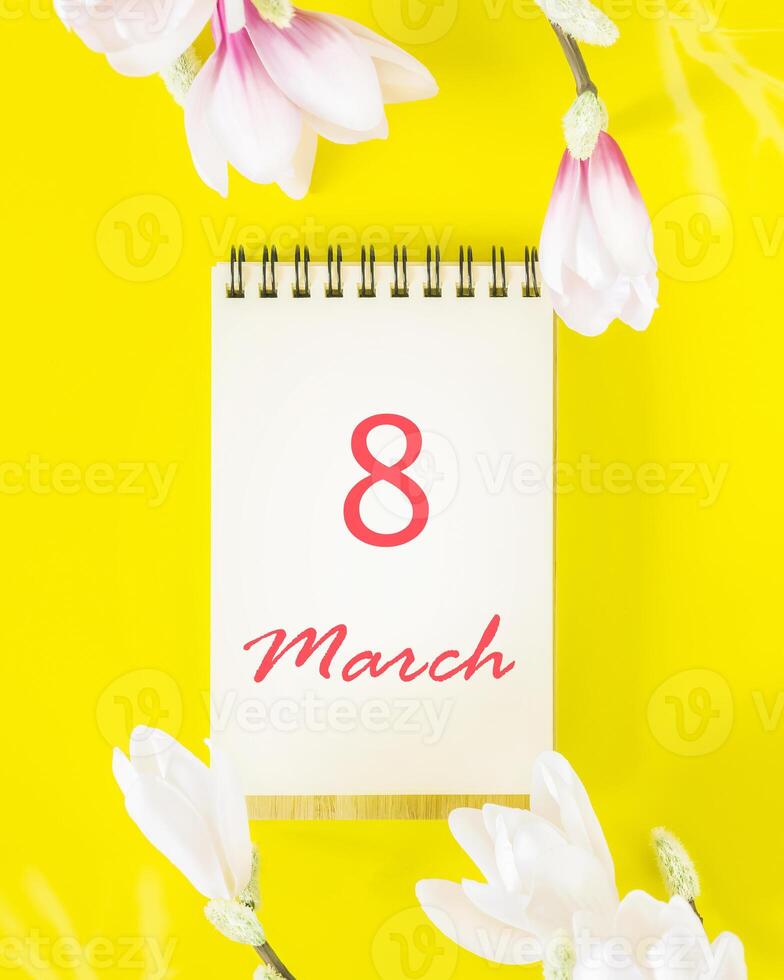 Magnolia flowers and notepade with inscription 8 March photo
