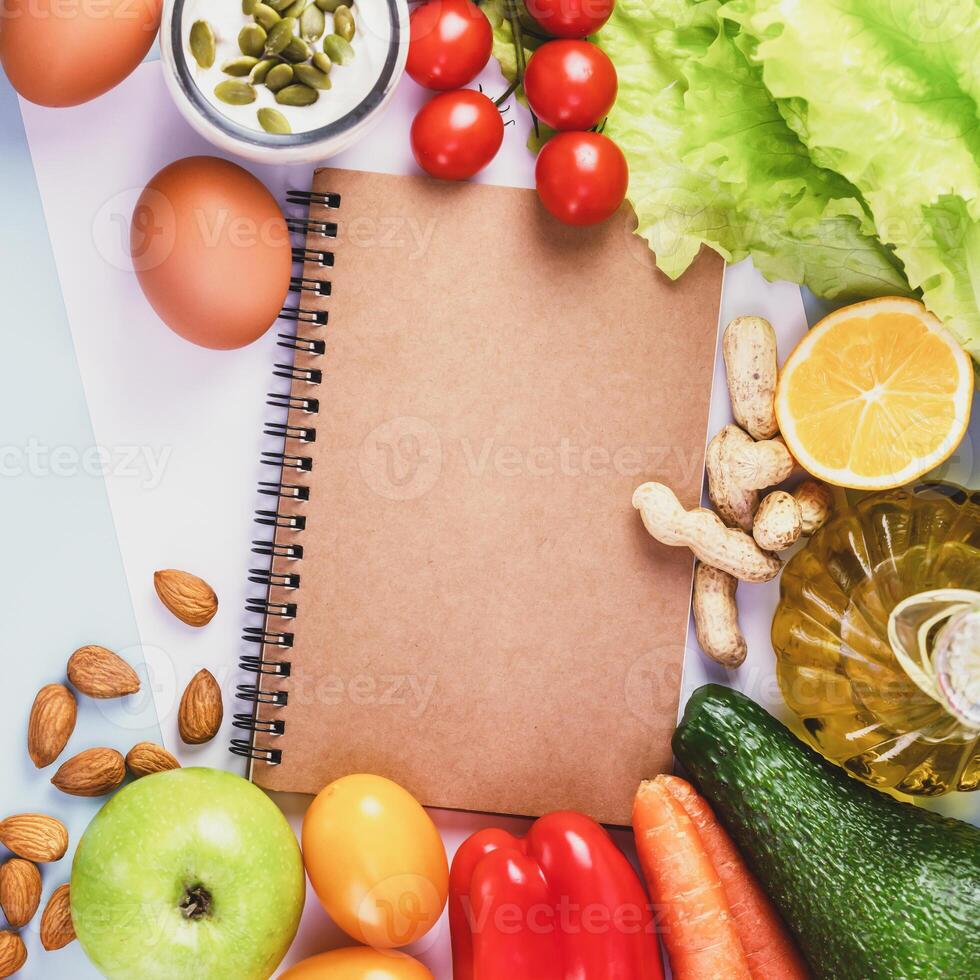 Concept of healthy food with fruits, vegetables, olive oil and diet diary photo