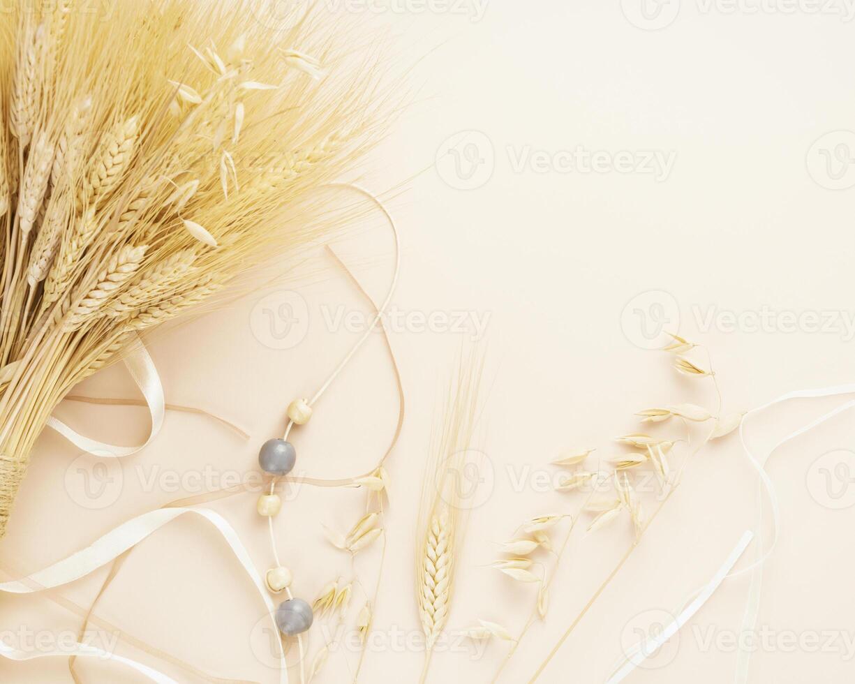 Bouquet of wheat and rye ears with decorations on a ivory background photo