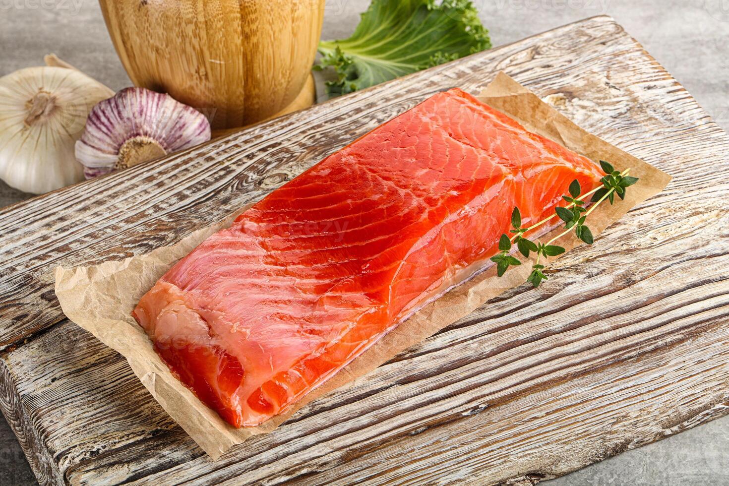 Raw salmon fillet over board photo