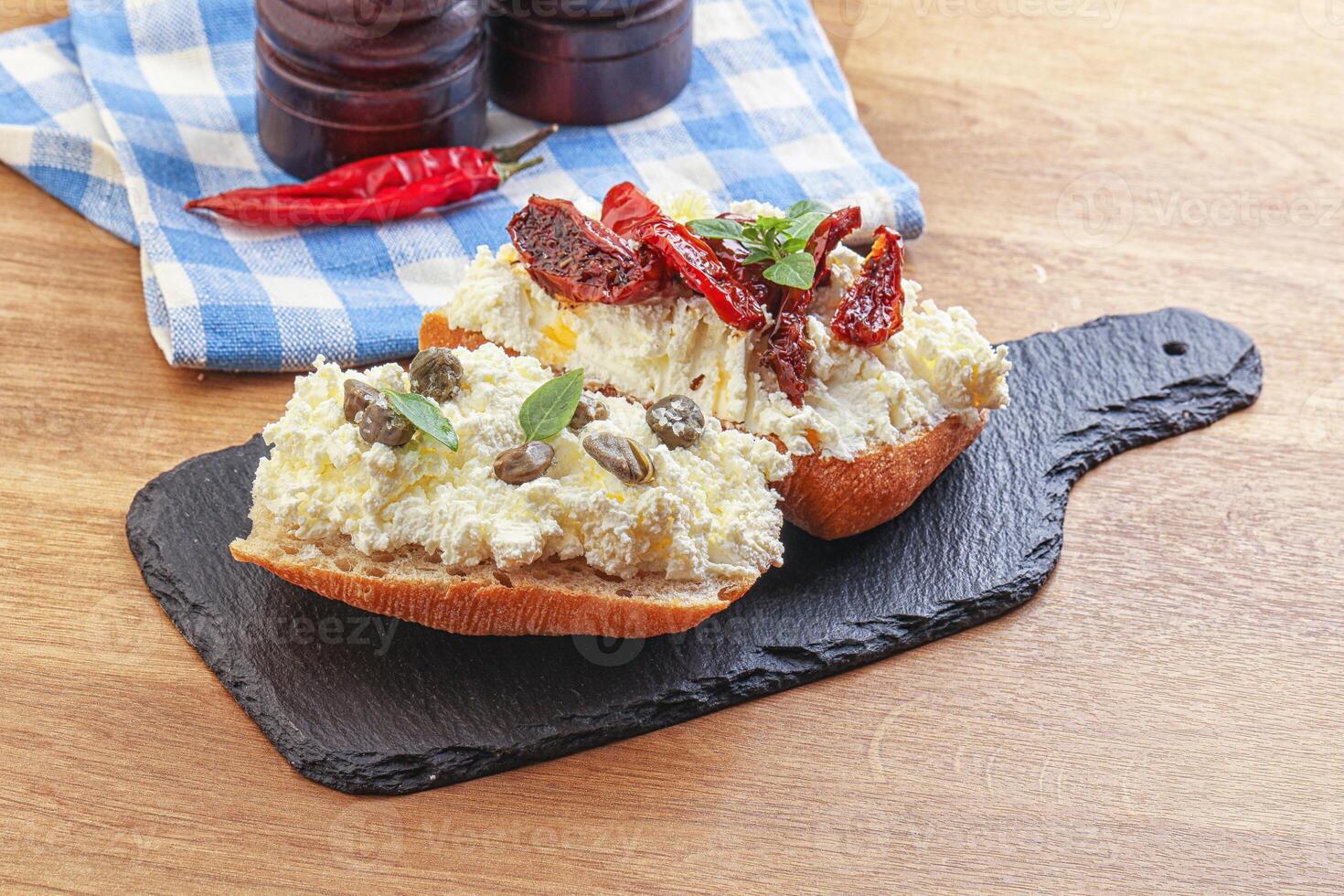 bruschetta with soft cheese capers and tomato photo