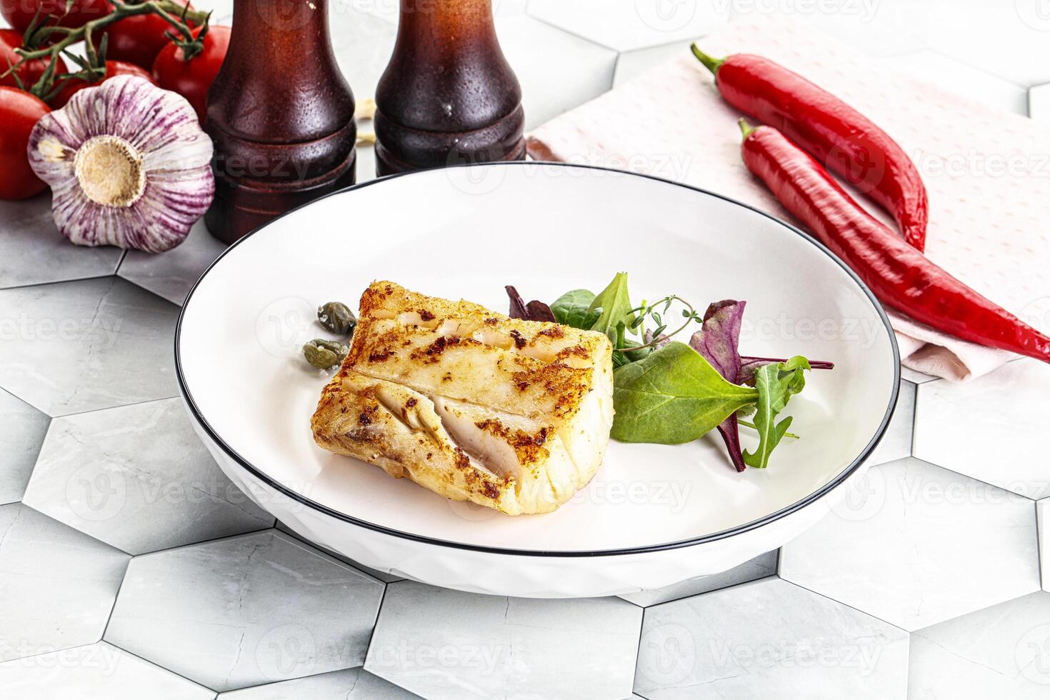 Roasted cod fish steak with salad photo