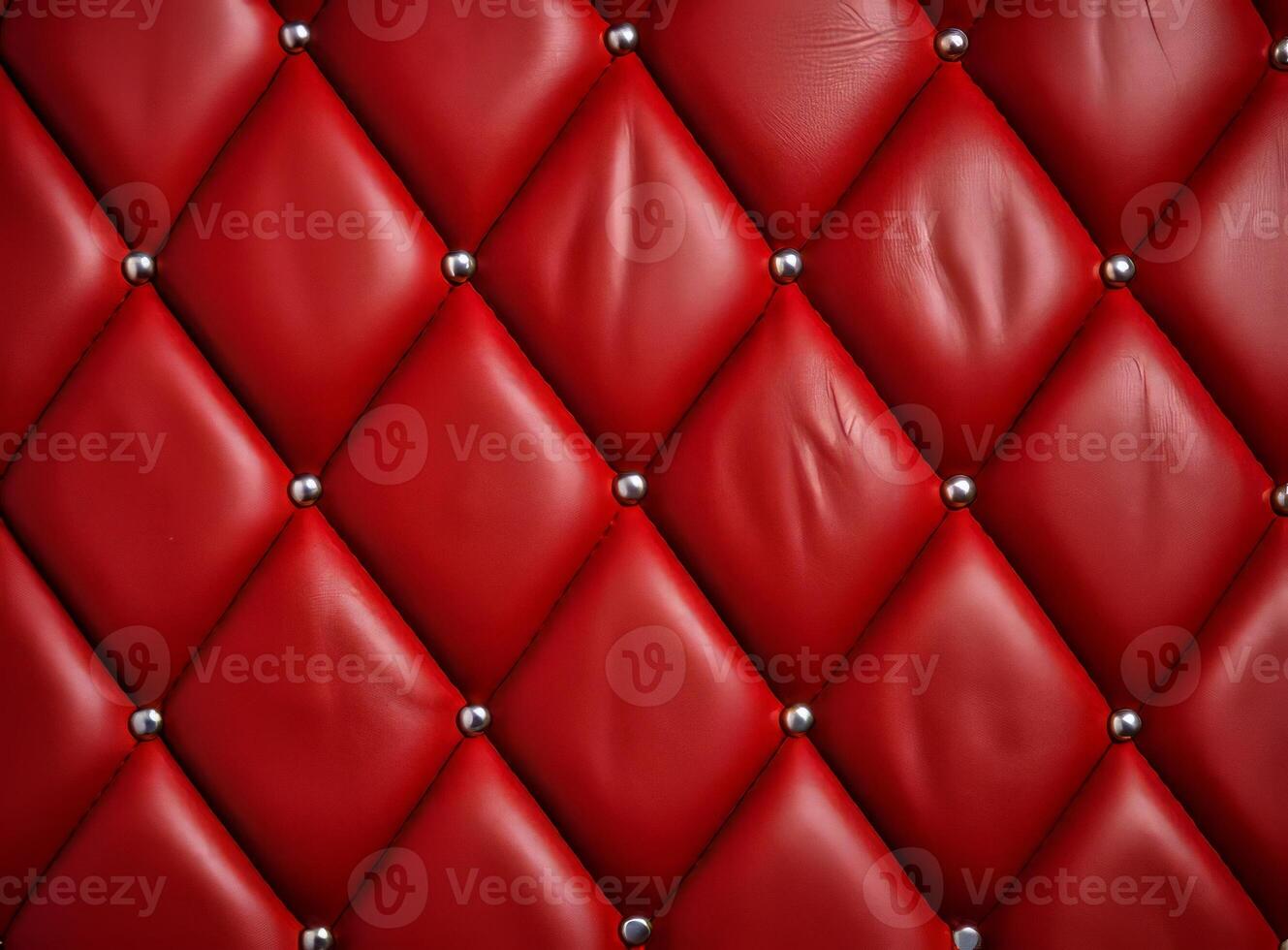 A close-up view of a luxurious red leather upholstery with decorative studs. photo