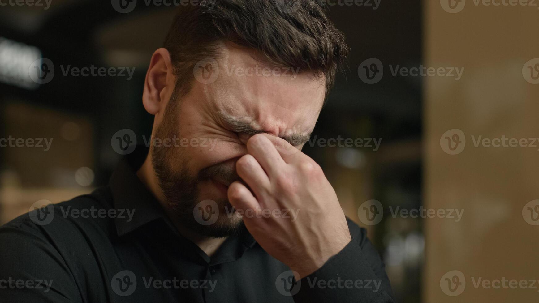 Close up anxious stressed Caucasian man tired upset guy rub dry irritated eyes feel pain ache eye strain sad male businessman crying tears bad vision discomfort suffer astigmatism syndrome headache photo