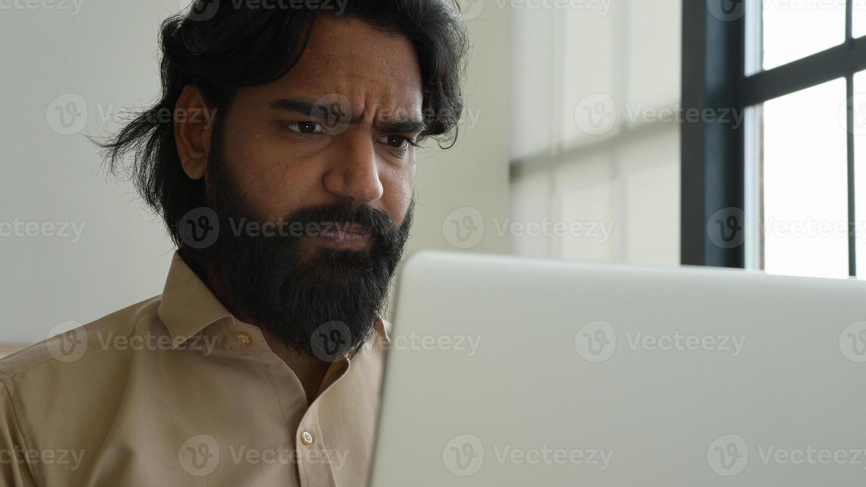 Unhappy concerned Indian Arabian businessman ethnic man chief ceo working with laptop business work at home office read bad unpleasant email trouble mistake problem crisis fail difficult project upset photo