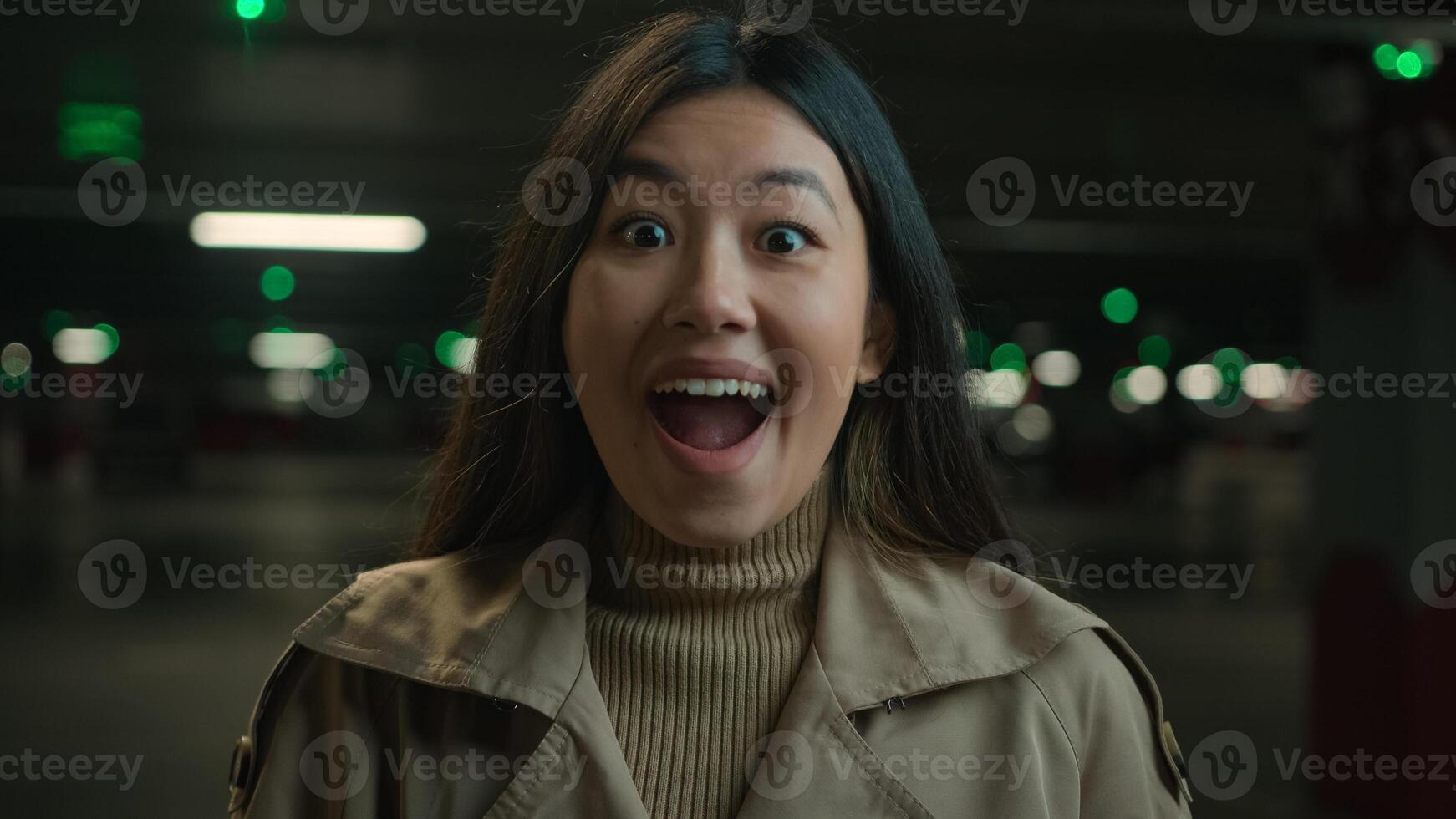 Portrait shocked surprised Asian woman chinese korean japanese happy ethnic girl wonder amazed female open mouth wow amazing unexpected shock surprise happy astonishment reaction at dark car parking photo