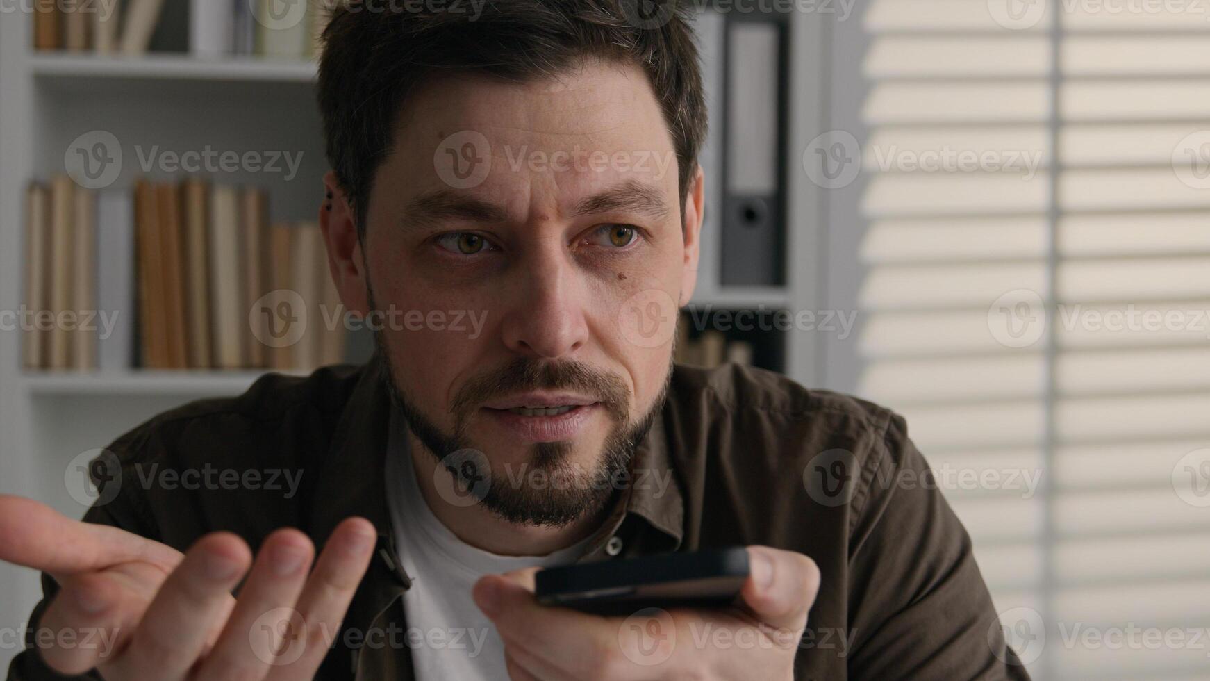 Angry stressed man office worker entrepreneur Caucasian businessman talk mobile phone record voice audio message voicemail on speakerphone AI technology loudspeaker business problem negative failure photo