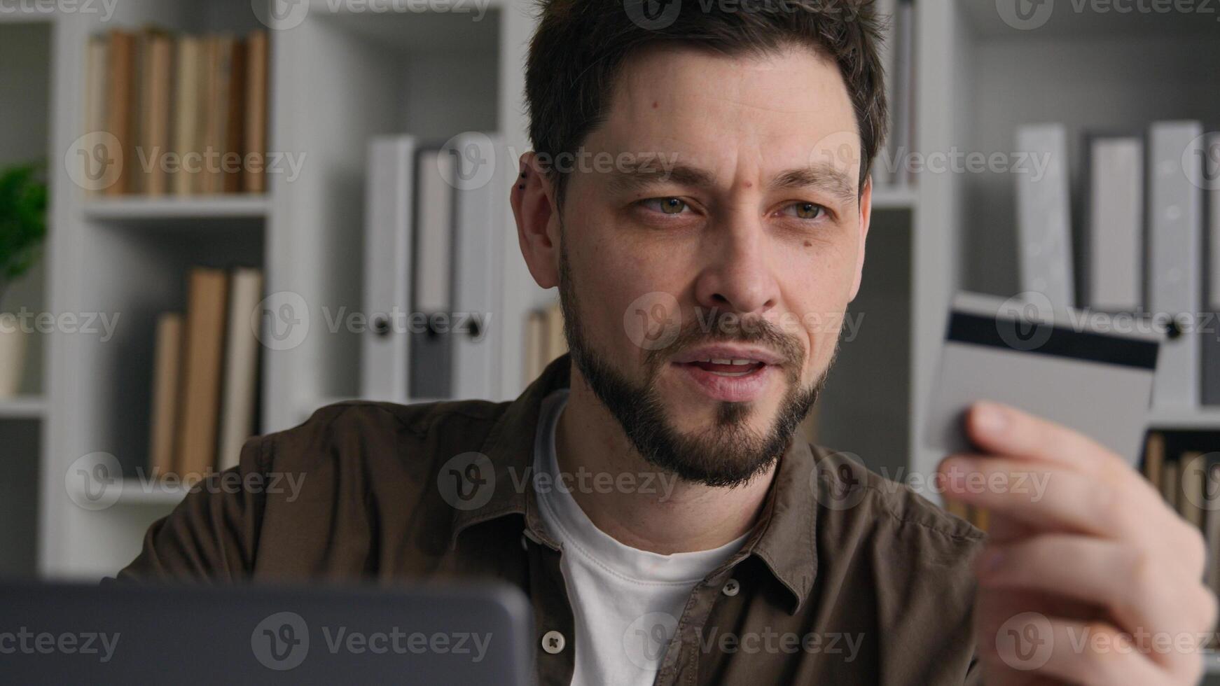 Smiling Caucasian business man businessman male customer shopper buyer pay with credit card online bank on laptop order pay purchase in internet store successful secure money transaction on computer photo
