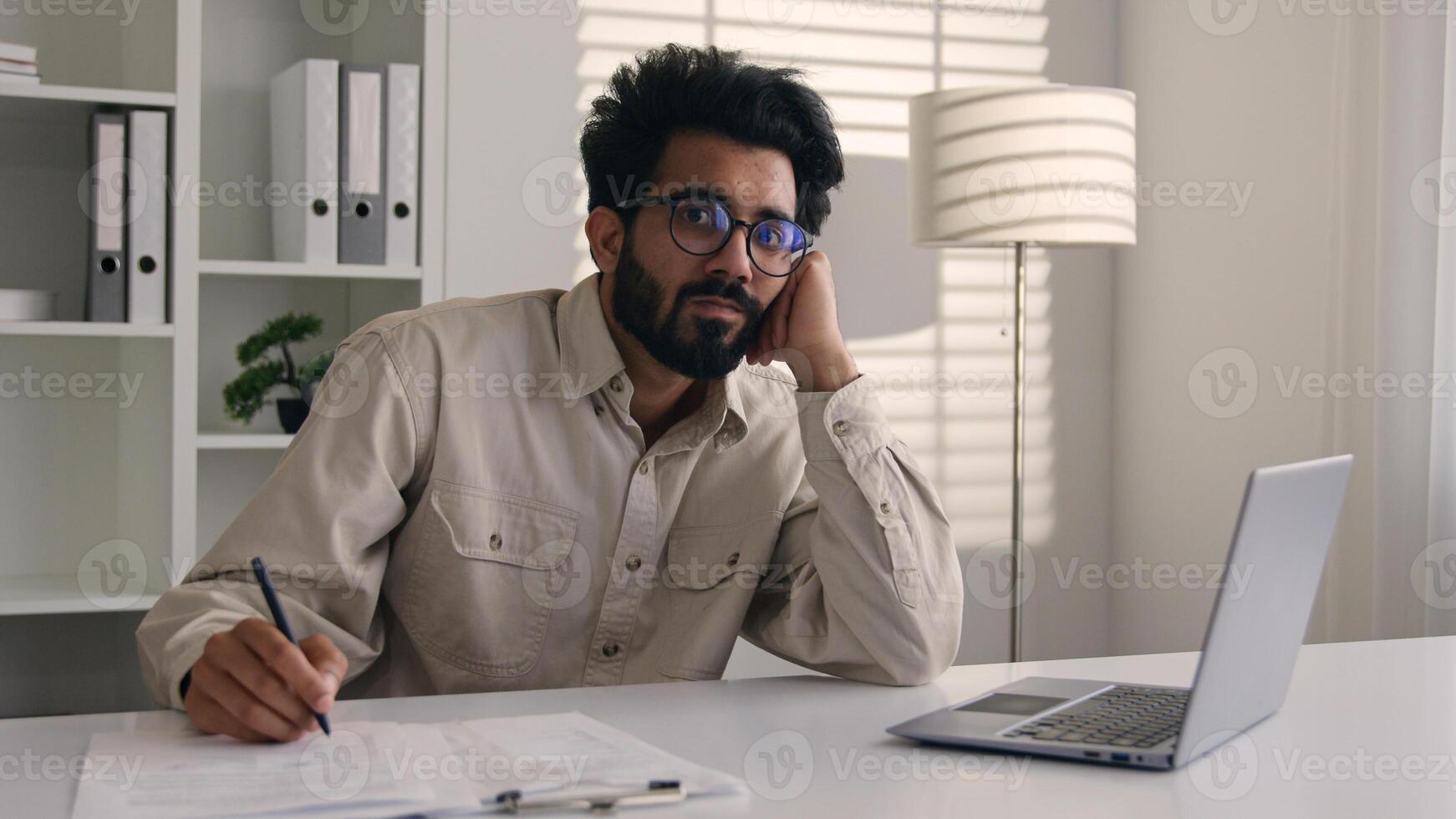 Tired bored Arabian Indian man businessman lazy employee manager boring job working with laptop studying write business project depression burnout fatigued overworked drowsy sleepy male guy at office photo