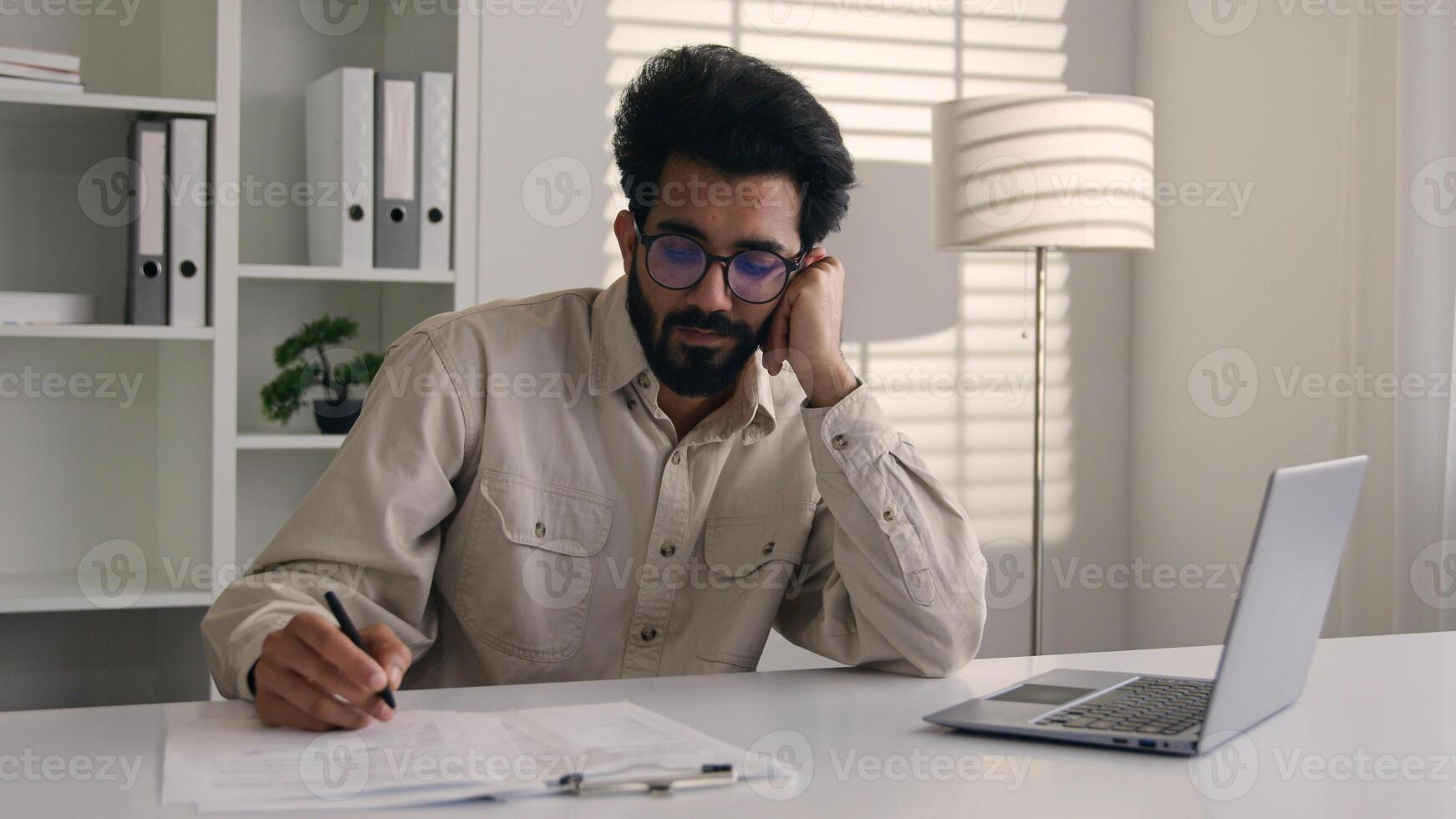 Tired bored Arabian Indian man businessman lazy employee manager boring job working with laptop studying write business project depression burnout fatigued overworked drowsy sleepy male guy at office photo