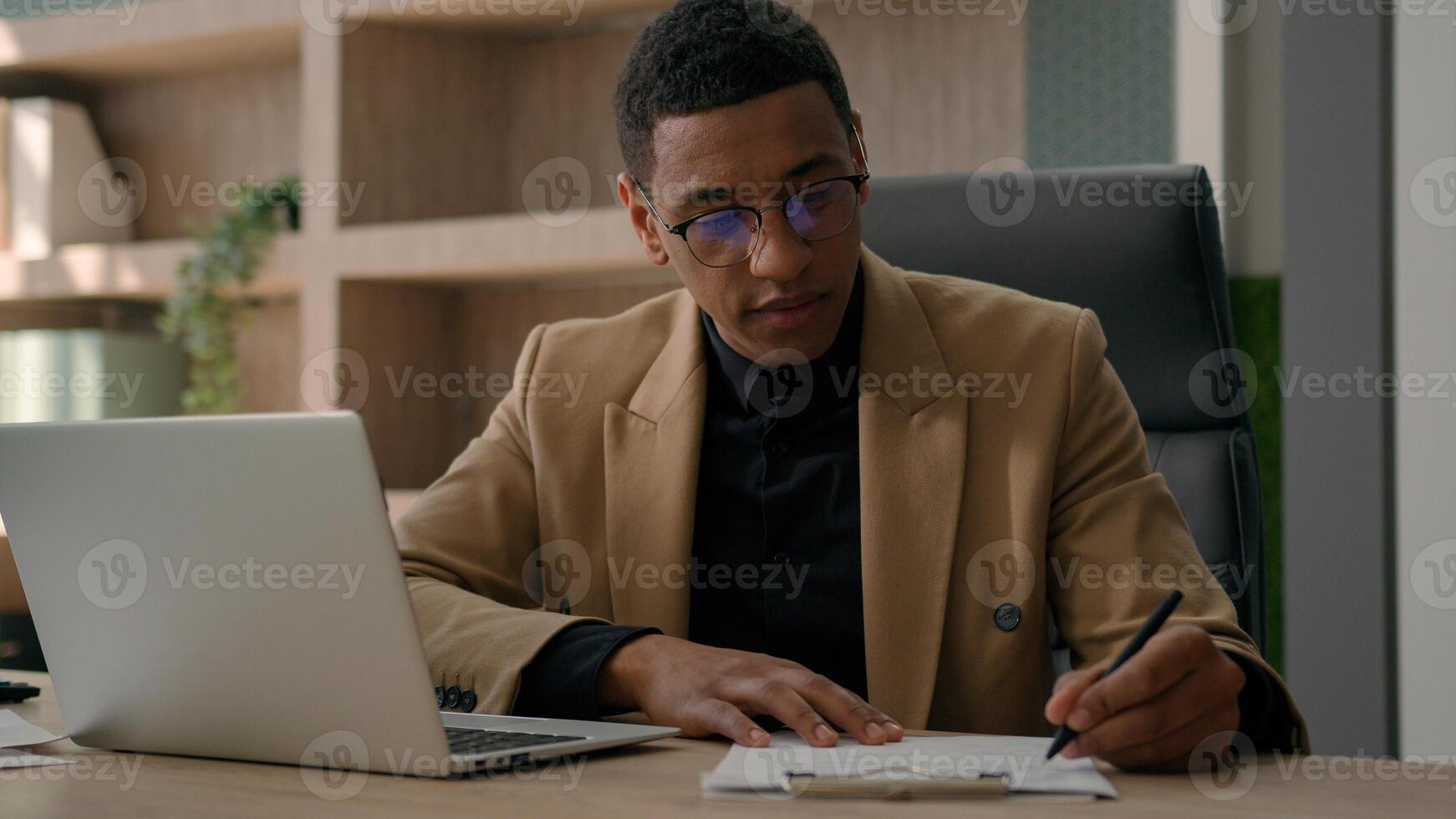 African American man accountant businessman manager analyst write notes data information writing business budget project report paperwork in office studying online with laptop educational course smile photo