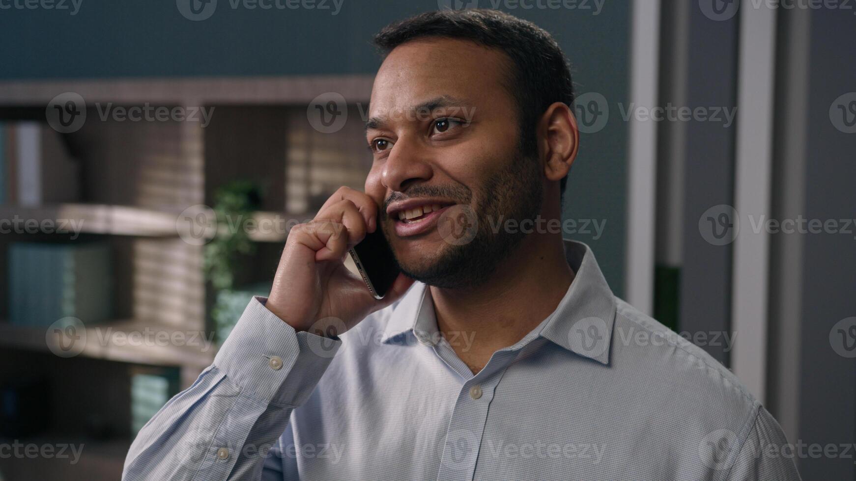 Smiling Arabian Indian business man talking mobile phone distant negotiate sales talk communicate with colleagues consult client in office businessman call speaking smartphone discuss talk cellphone photo