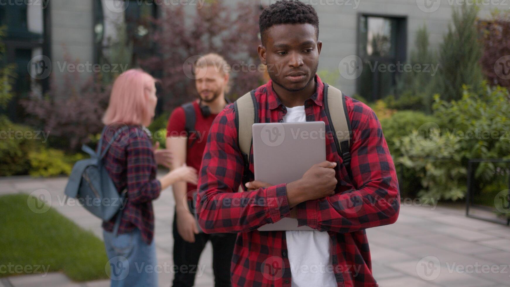 Group of angry students teenagers multiracial classmates laughing humiliate bully mockery at college university outdoors discriminate mock African American sad upset man student stressed guy problem photo