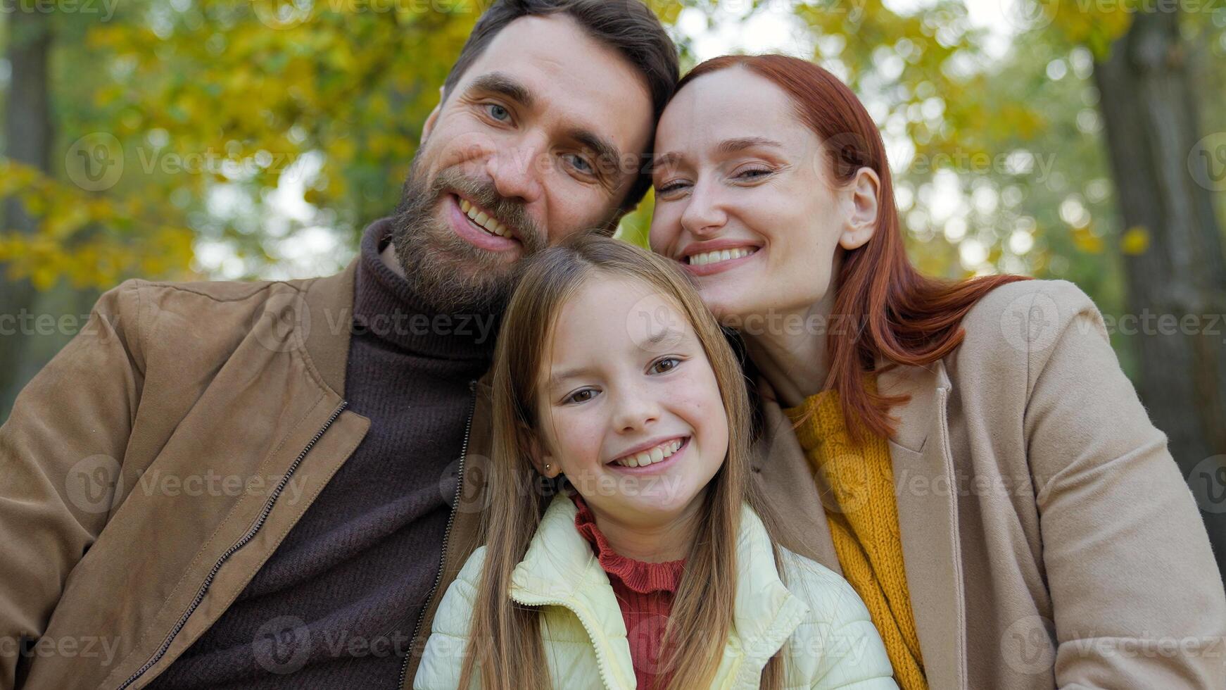 Cheerful family together happy laughing man father woman mother child kid girl little daughter outdoors in park sitting on bench smiling affection childhood dad mom baby laugh smile at camera portrait photo