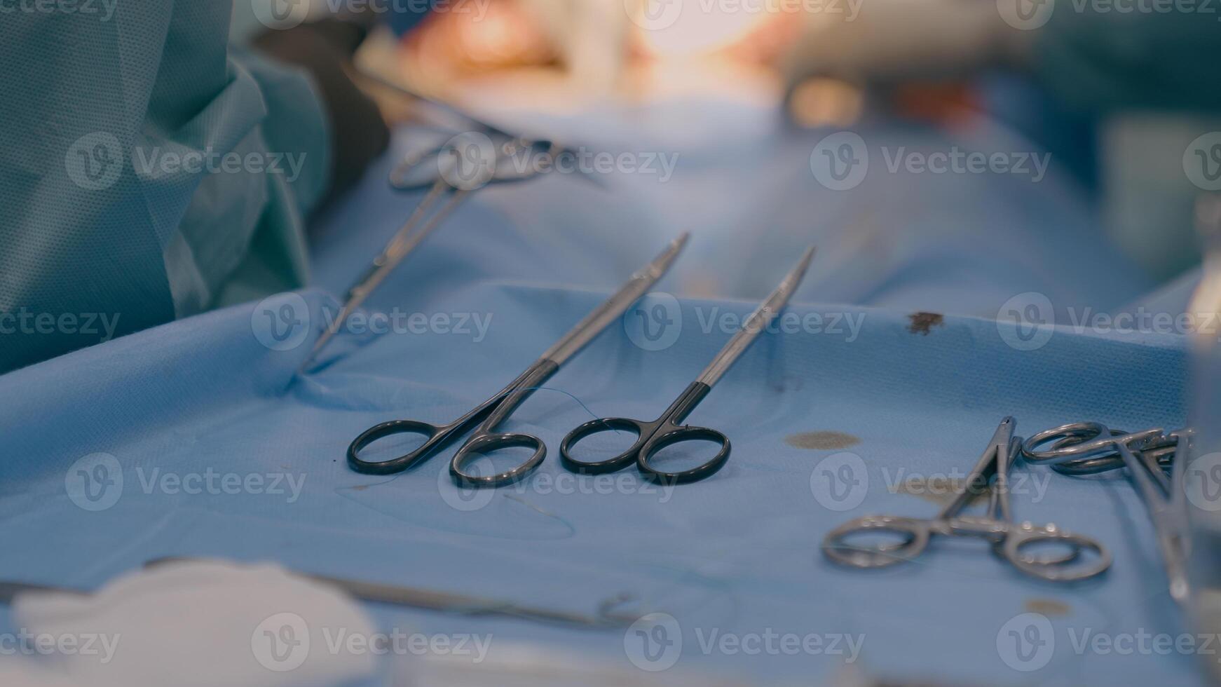 Close up multiple surgery tools on table in operating room team surgeons doctors perform medical operation using scalpels forceps scissors surgical instruments modern medicine health care in hospital photo