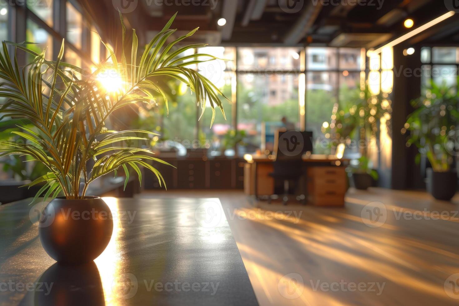 A large, empty office room with a sun shining through the windows. Modern space is made of glass and has a shiny, reflective surface photo
