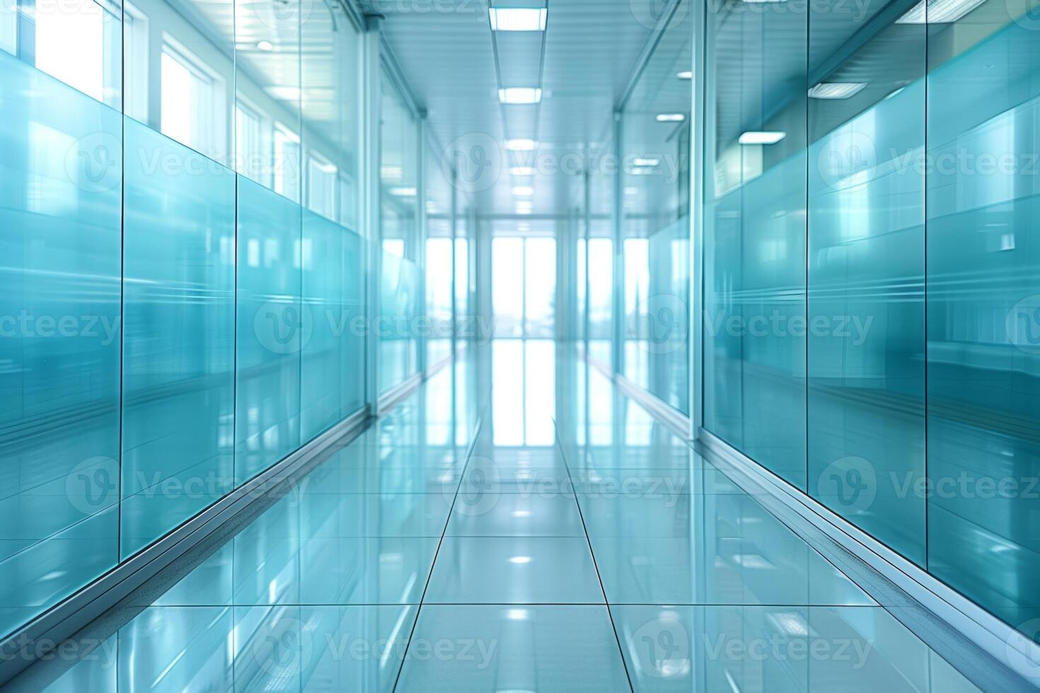 A large, empty office room with a sun shining through the windows. Modern space is made of glass and has a shiny, reflective surface photo