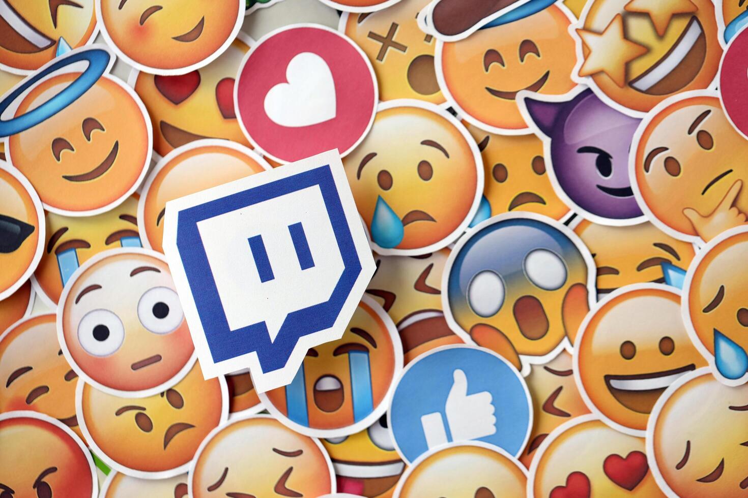 KYIV, UKRAINE - APRIL 20, 2024 Twitch logo and large set of stickers with Emoji yellow faces. Emoji is a pictogram or smiley embedded in text and used in electronic messages photo