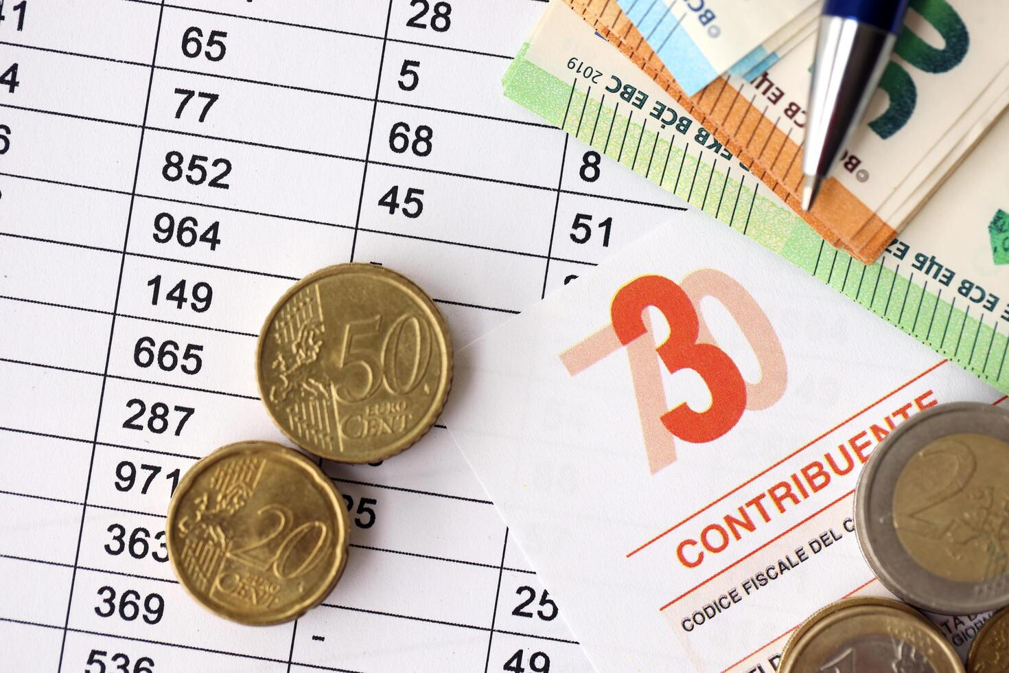 KYIV, UKRAINE - APRIL 20, 2024 many euro banknotes with the Modello 730 tax form as background, translating in Italian as declaration of incomes photo