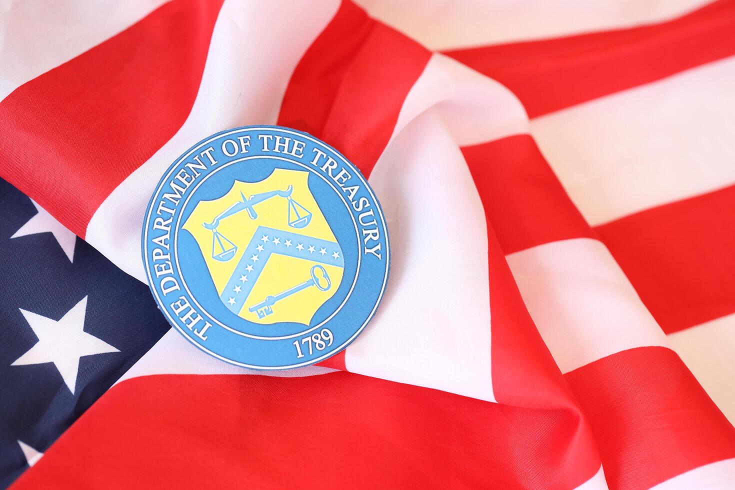 KYIV, UKRAINE - MARCH 9, 2024 US The Department of the Treasury seal on United States of America flag photo