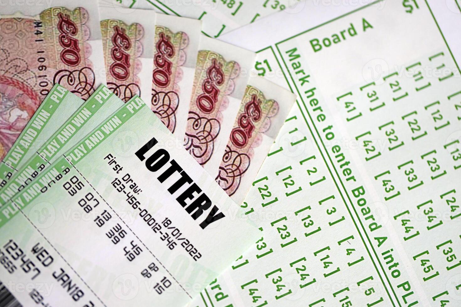 Green lottery tickets and Great Britain pounds money bills on blank with numbers for playing lottery photo