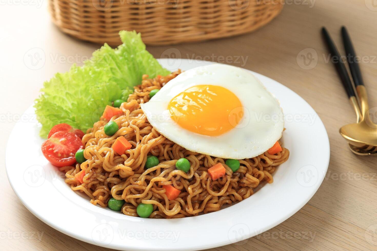 Close Up Indomie Goreng, Stir Fried Instant Noodles with Sunny Side Egg on Top. photo