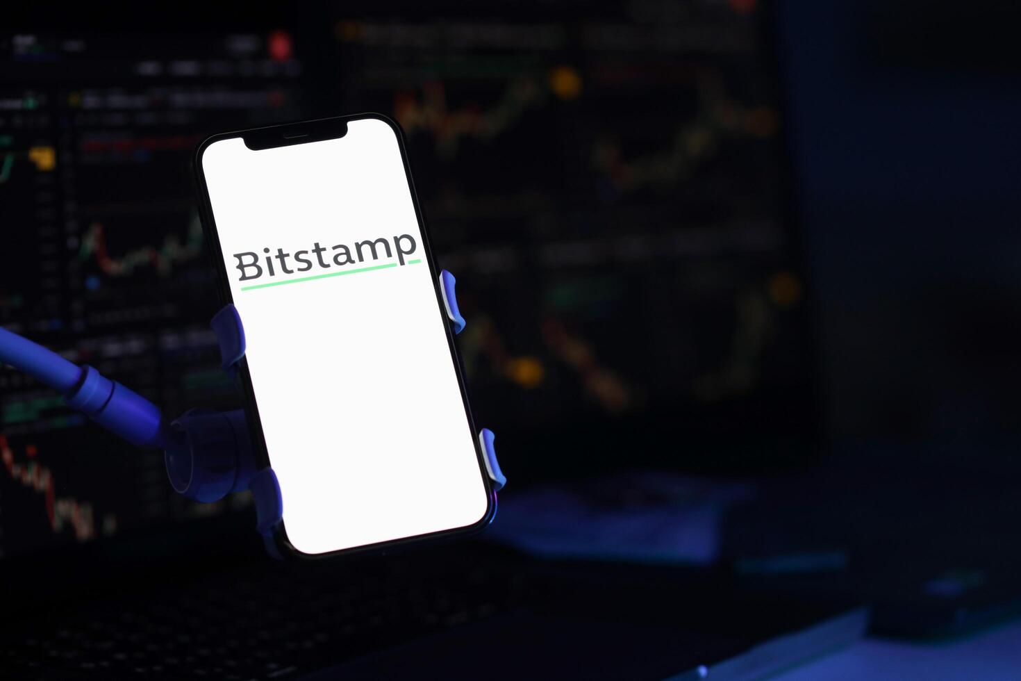 KYIV, UKRAINE - MARCH 15, 2024 Bitstamp logo on iPhone display screen and crypto currency value charts photo