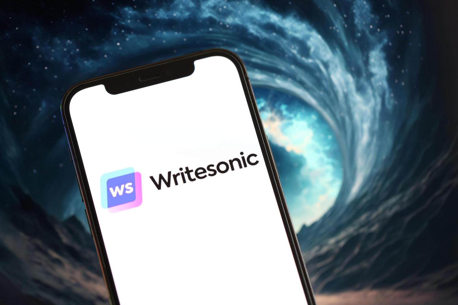 KYIV, UKRAINE - MARCH 17, 2024 Writesonic logo on iPhone display screen with background of artificial intelligence futuristic image photo