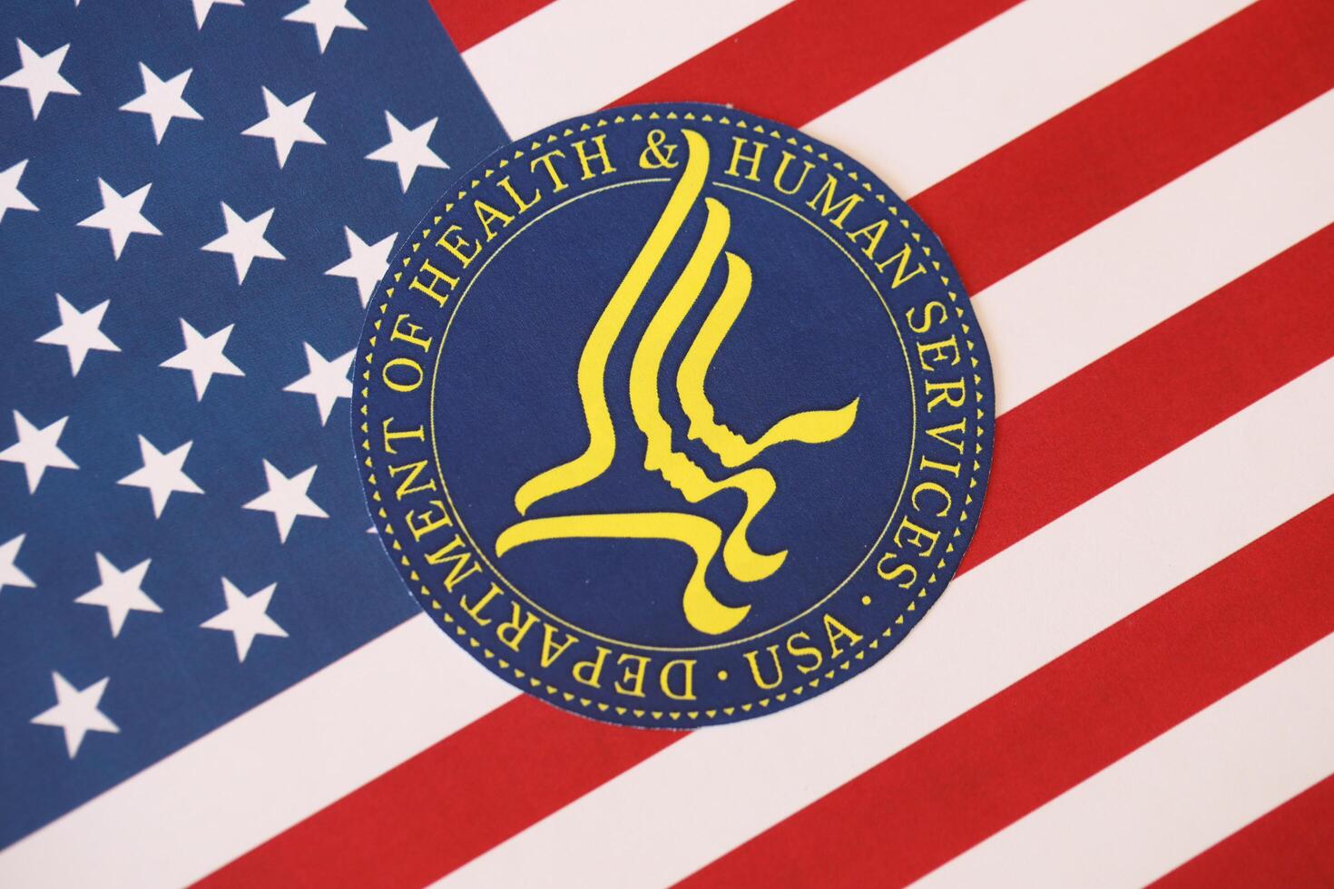 KYIV, UKRAINE - MARCH 9, 2024 US Department of Health and human Services seal on United States of America flag photo