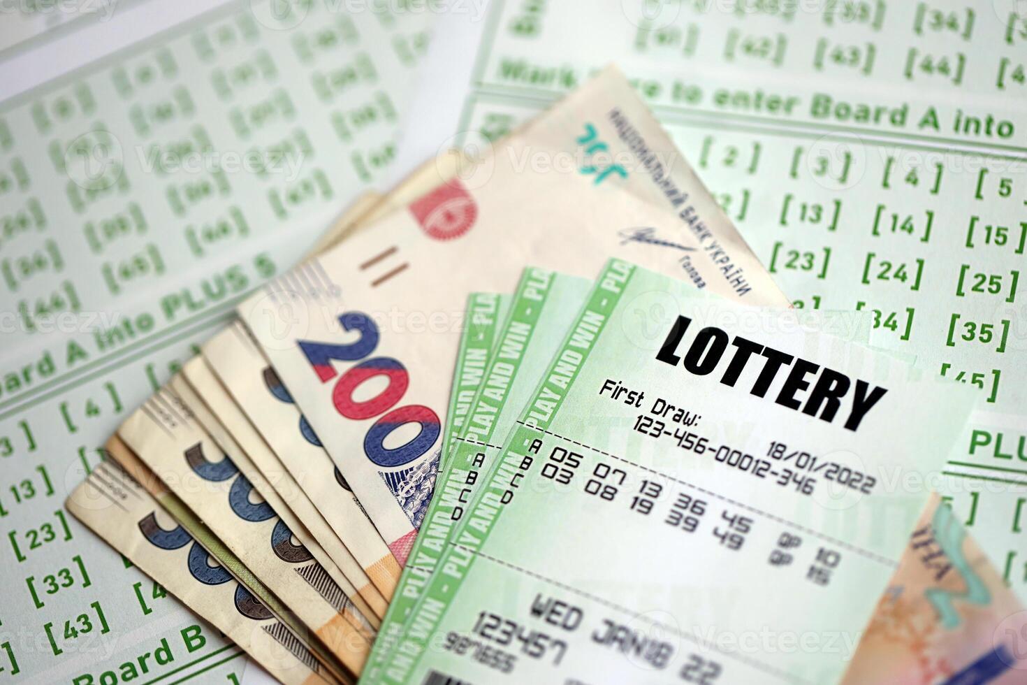 Green lottery tickets and ukrainian money bills on blank with numbers for playing lottery photo