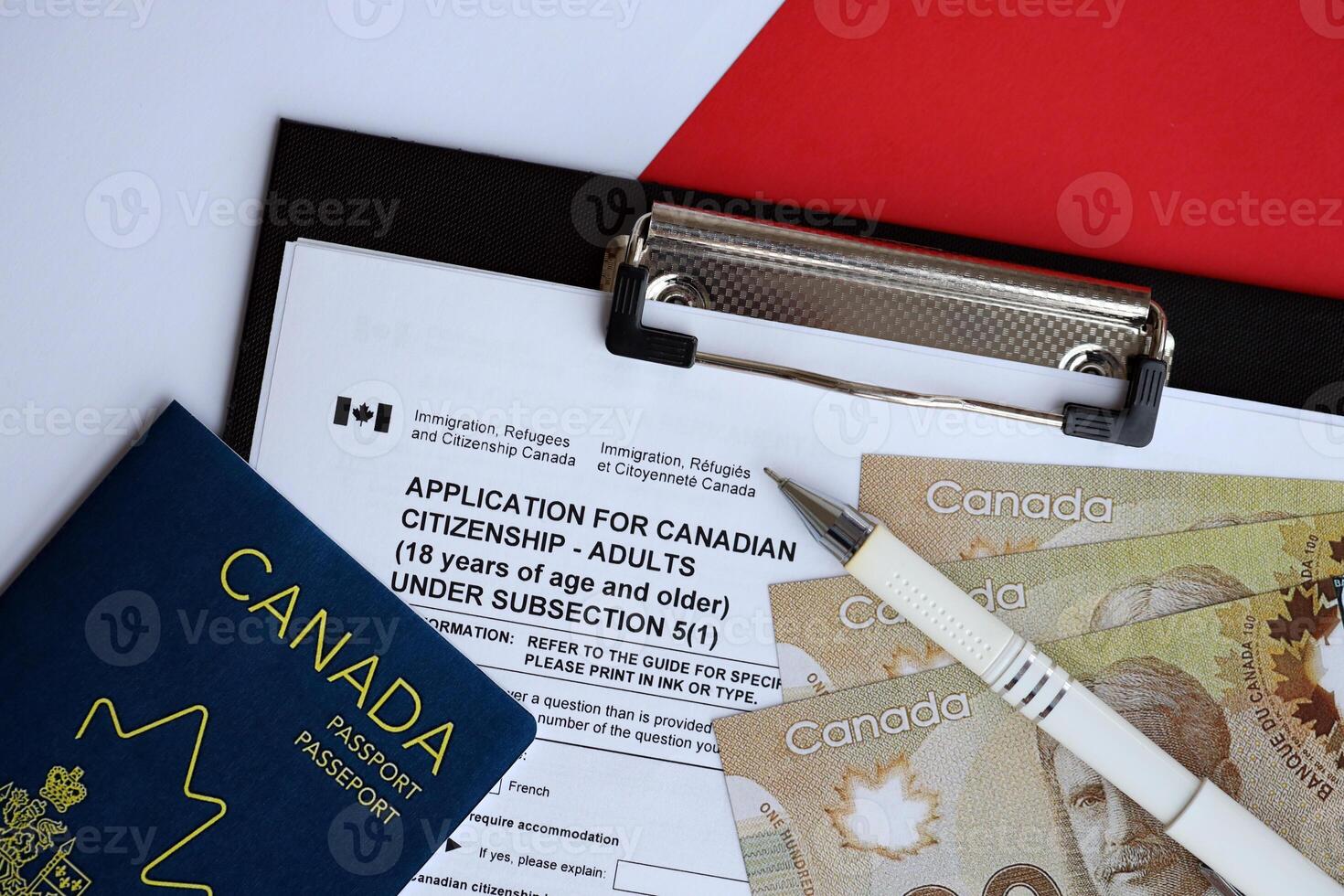 Application for Canadian citizenship for adults on table with pen, passport and dollar bills photo