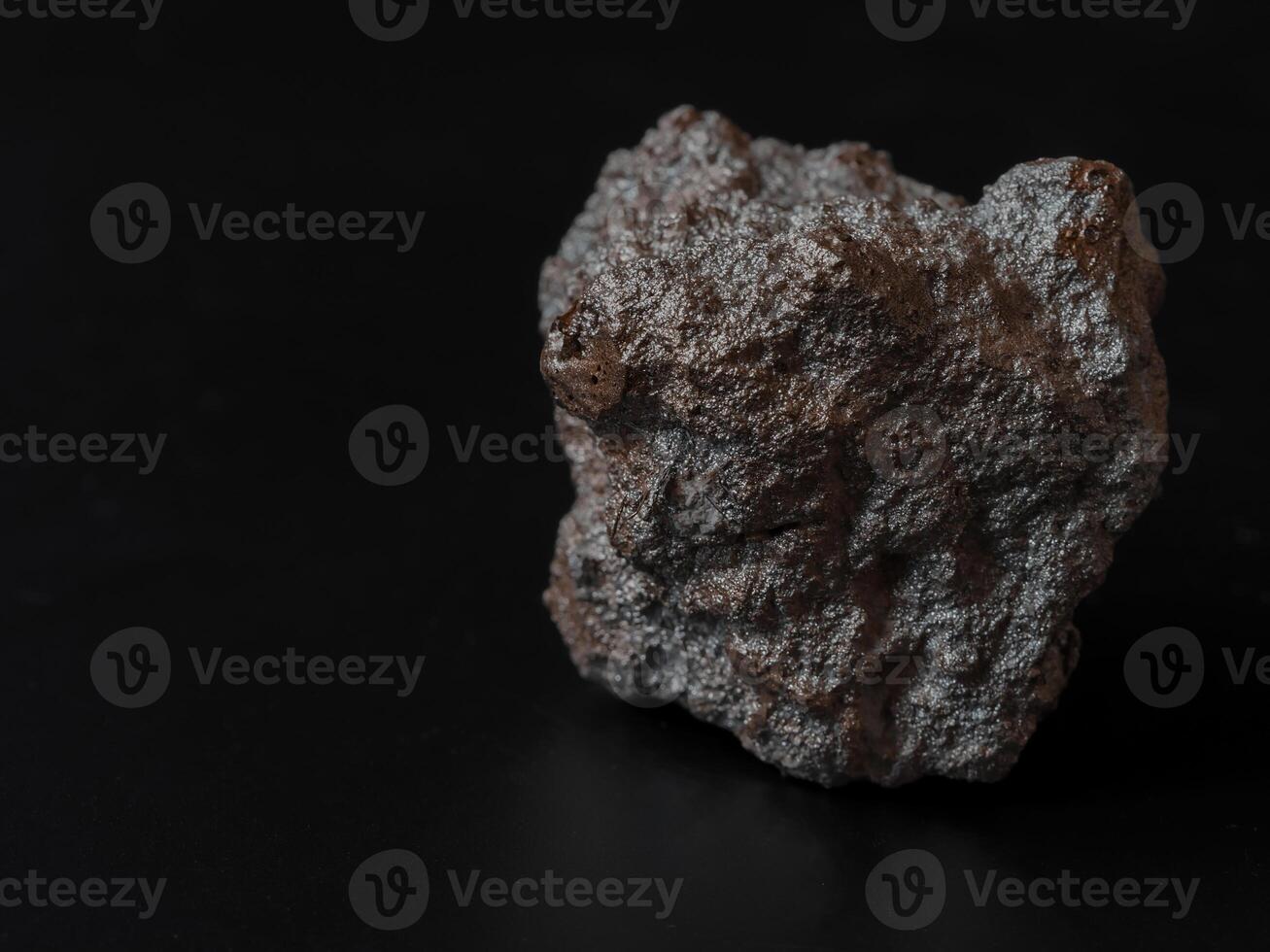 Closeup pure gold nugget from the mine on black background. Finance and business concept. photo