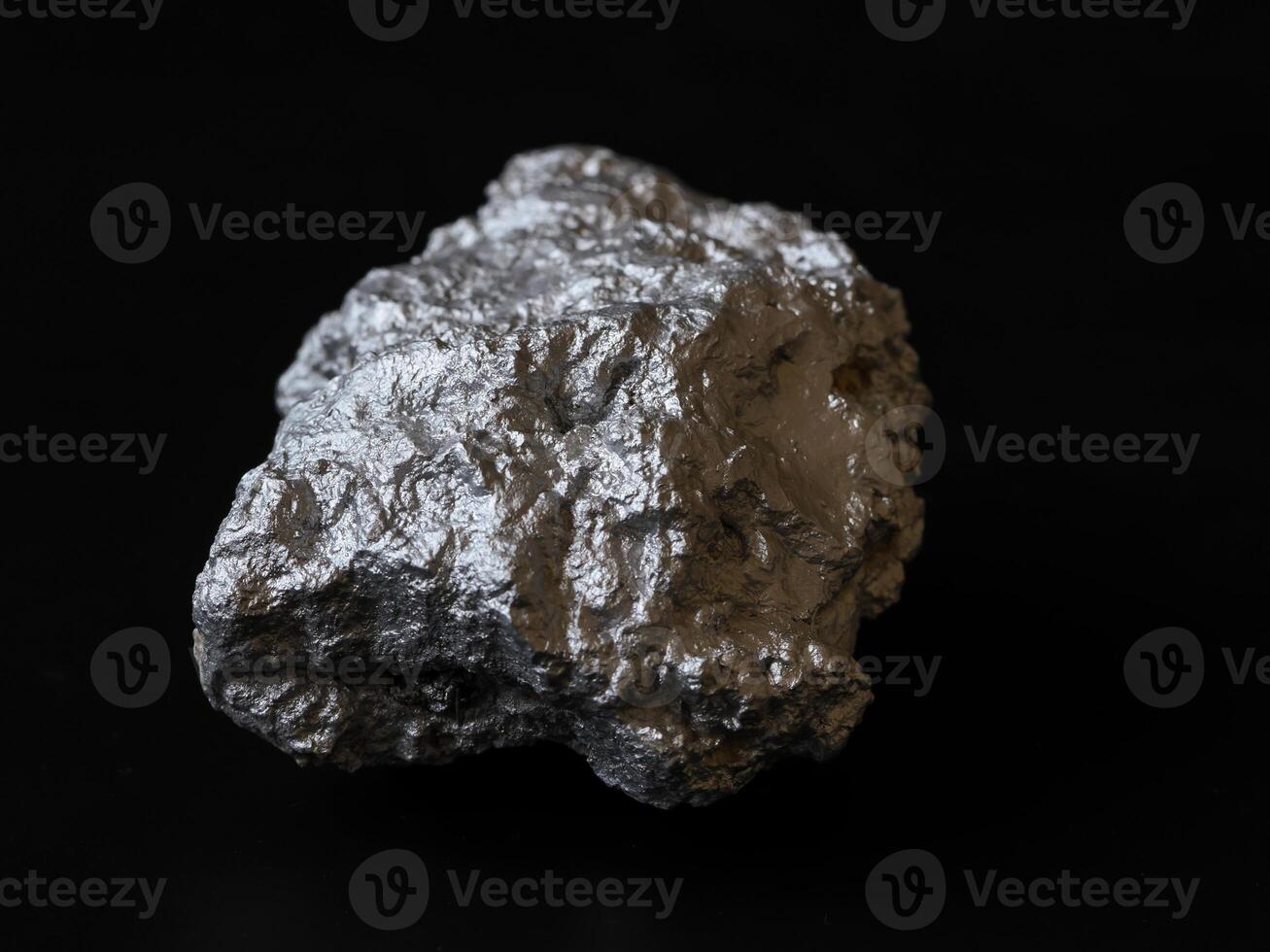 Closeup pure silver nugget from the mine on black background. Finance and business concept. photo