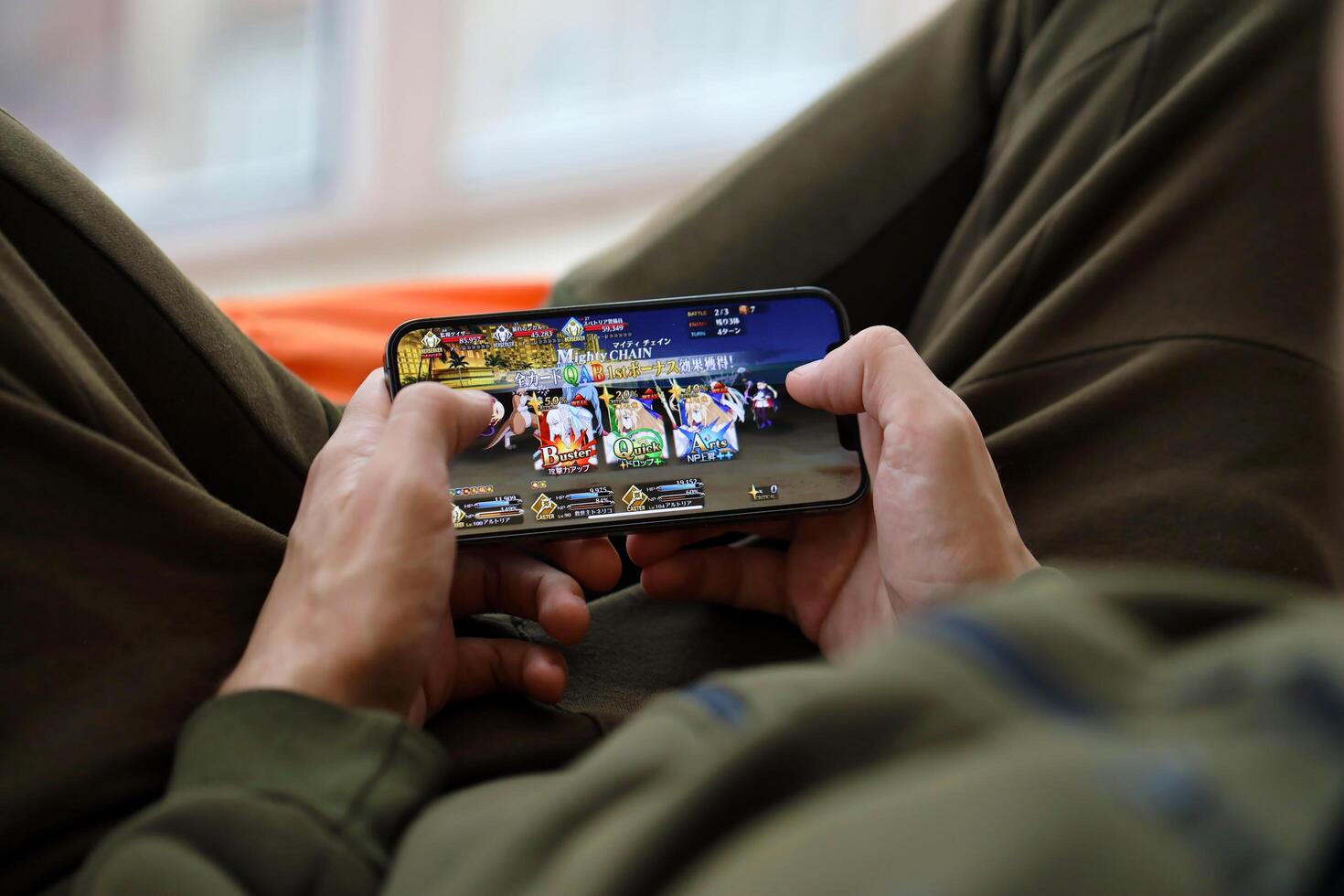 Fate Grand Order mobile iOS game on iPhone 15 smartphone screen in male hands during mobile gameplay photo