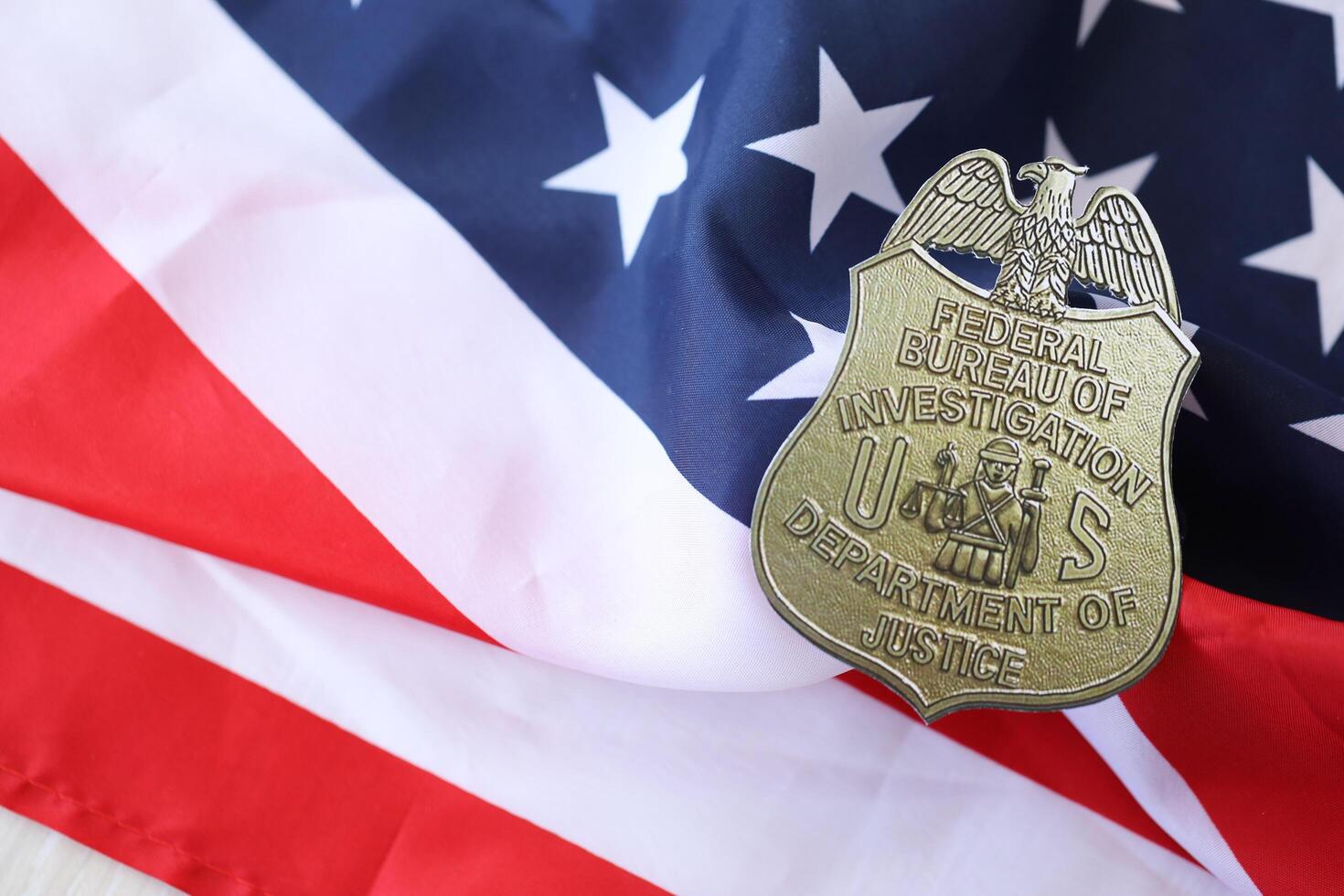 KYIV, UKRAINE - MARCH 9, 2024 US FBI Federal Bureau of Investigation badge on United States of America flag photo