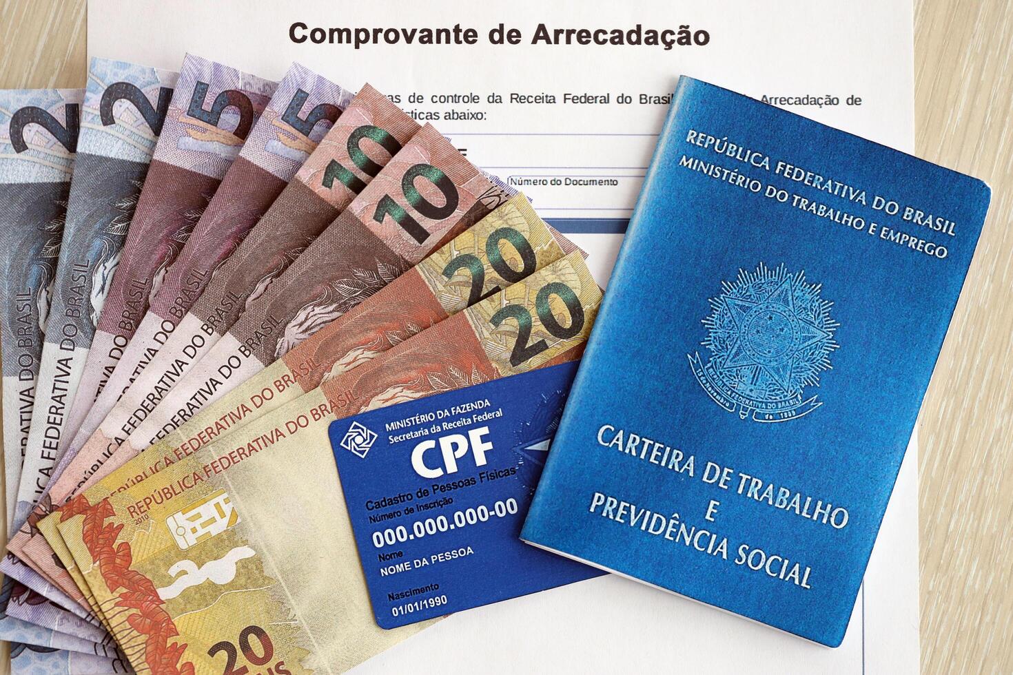 TERNOPIL, UKRAINE - JULY 7, 2023 Brazilian Work Permit document and Brazilian tax number card on table with tax form photo