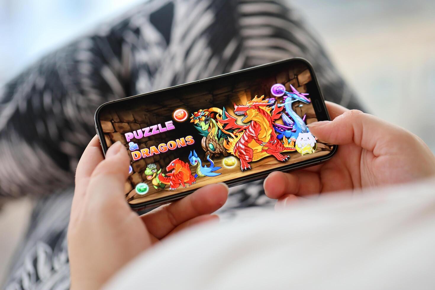 Puzzle and dragons mobile iOS game on iPhone 15 smartphone screen in female hands during mobile gameplay photo