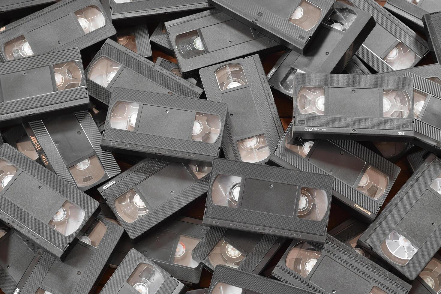 KYIV, UKRAINE - 4 MAY, 2023 tape on colored background, VHS, cassette. Messy stack of VHS tapes. Home System tape photo