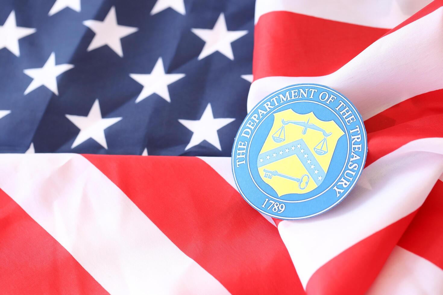 KYIV, UKRAINE - MARCH 9, 2024 US The Department of the Treasury seal on United States of America flag photo