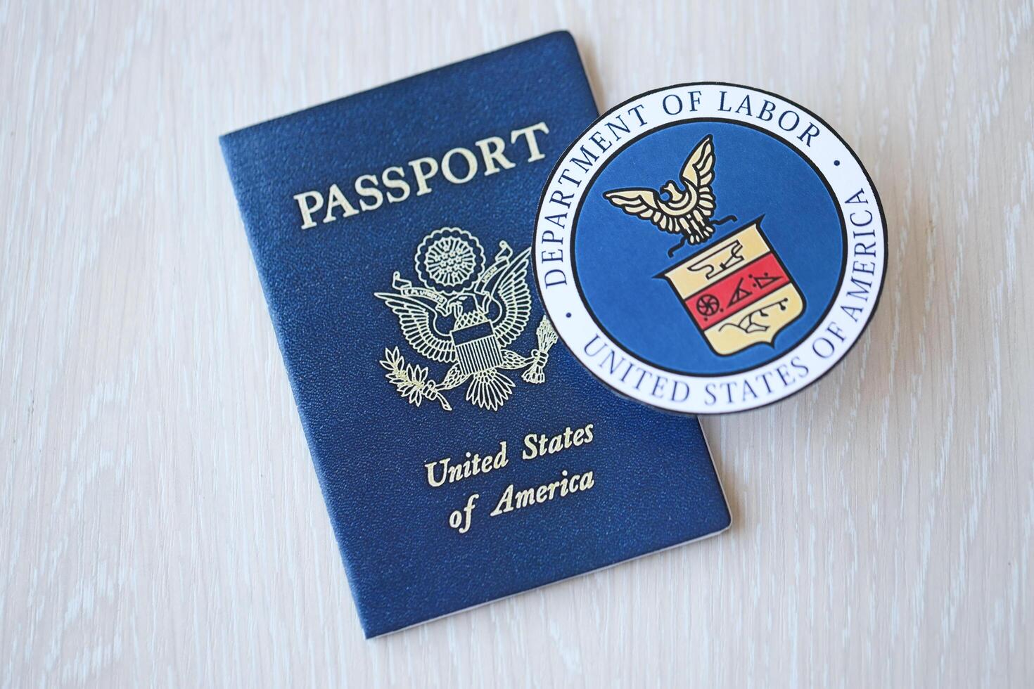 KYIV, UKRAINE - MARCH 9, 2024 US Department of Labor seal and United States passport on wooden table photo