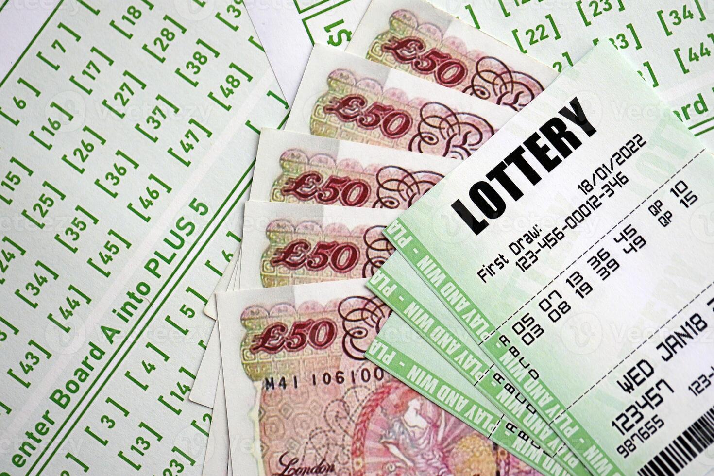 Green lottery tickets and Great Britain pounds money bills on blank with numbers for playing lottery photo