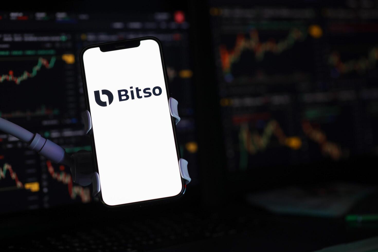 KYIV, UKRAINE - MARCH 15, 2024 Bitso logo on iPhone display screen and crypto currency value charts photo